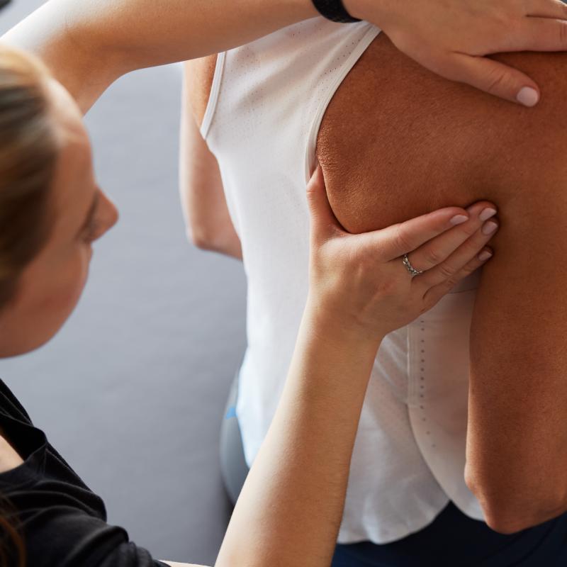 woman massaging a persons shoulder
